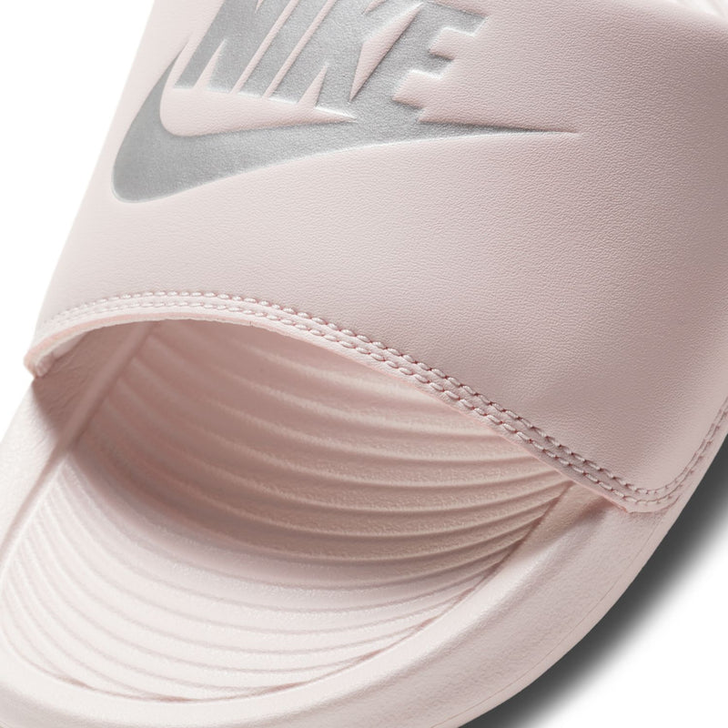 Women's Nike slide sandal close-up: Barely Rose strap, swoosh logo and stitching