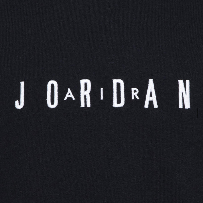 Close-up of embroidered JORDAN wordmark on youth black T-shirt chest