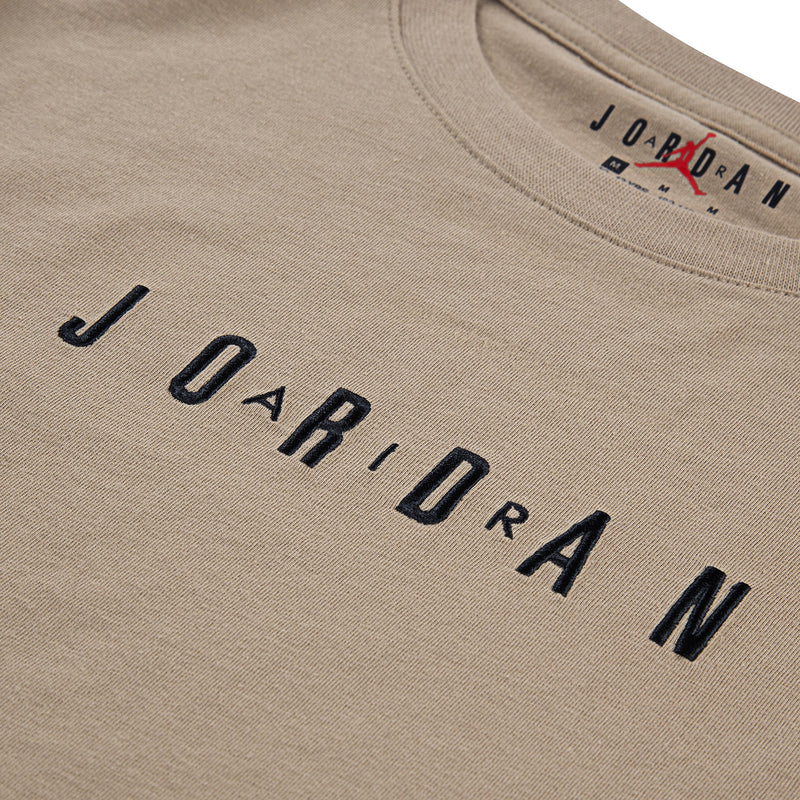 Tan crewneck T-shirt close-up of embroidered Jordan wordmark and neck label