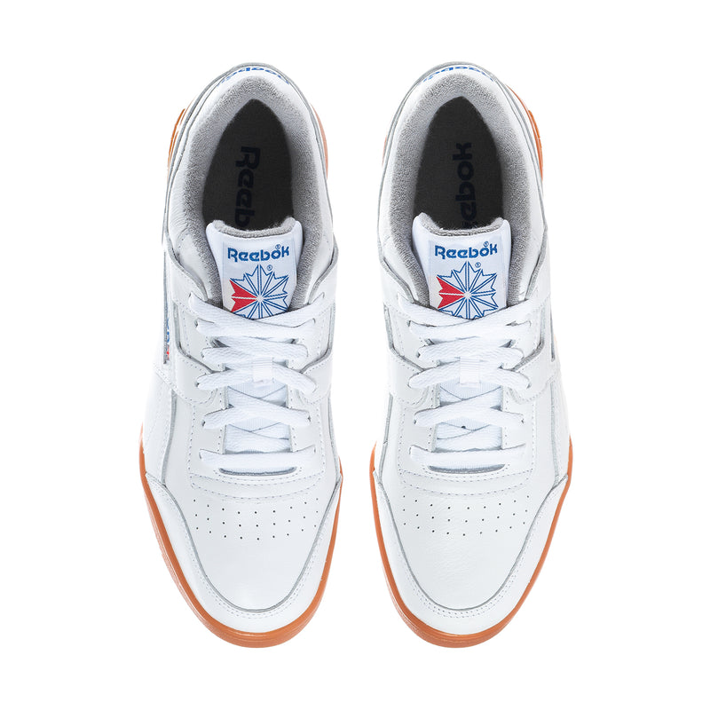 Pair of white Reebok sneakers with orange-trimmed outsole and blue tongue logo