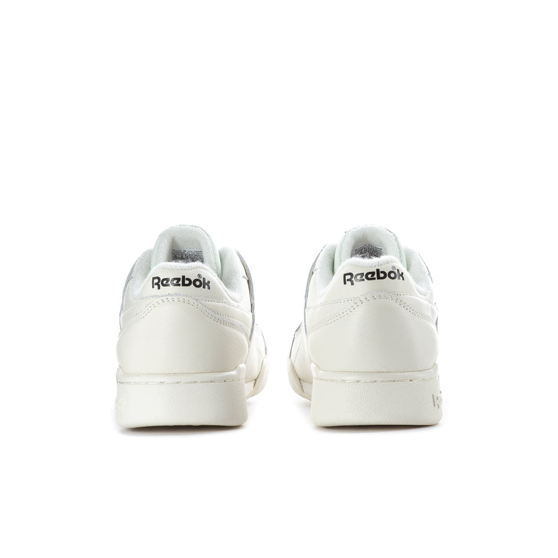 White low-top sneakers, back view, with Reebok heel branding.