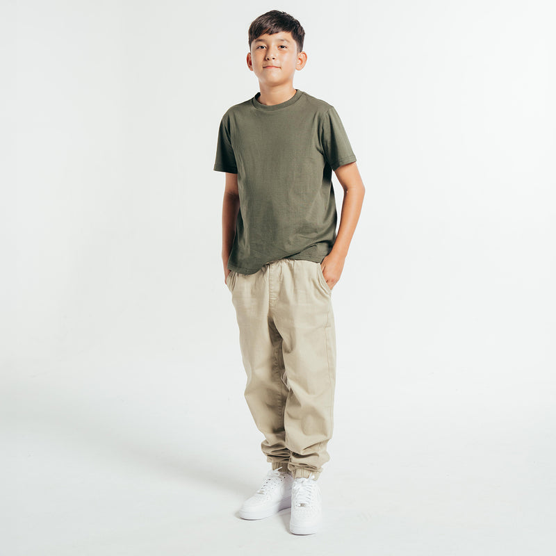 Youth woven jogger pants in light beige with elastic cuffs and relaxed fit