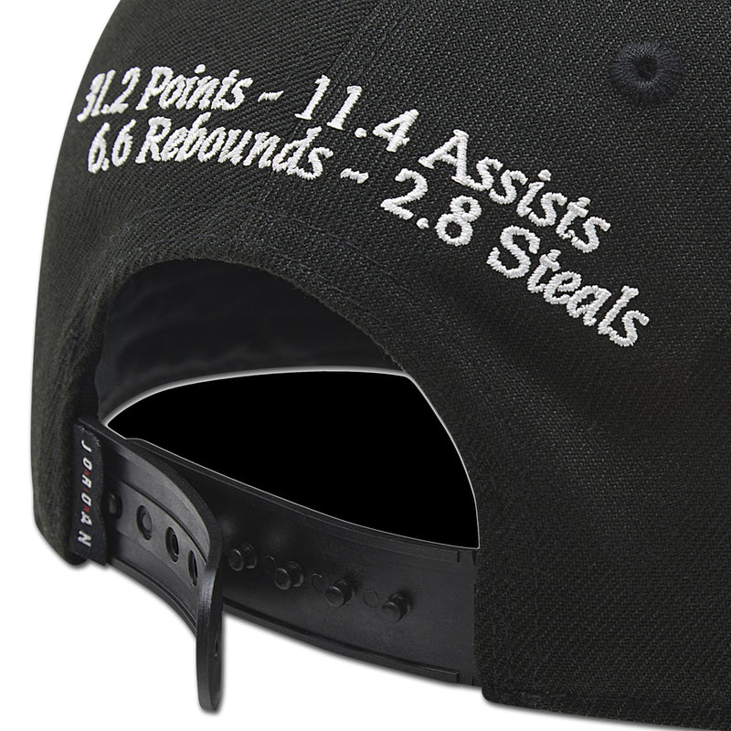 Black snapback cap close-up with white embroidered 11.4 Assists and 3.8 Steals text