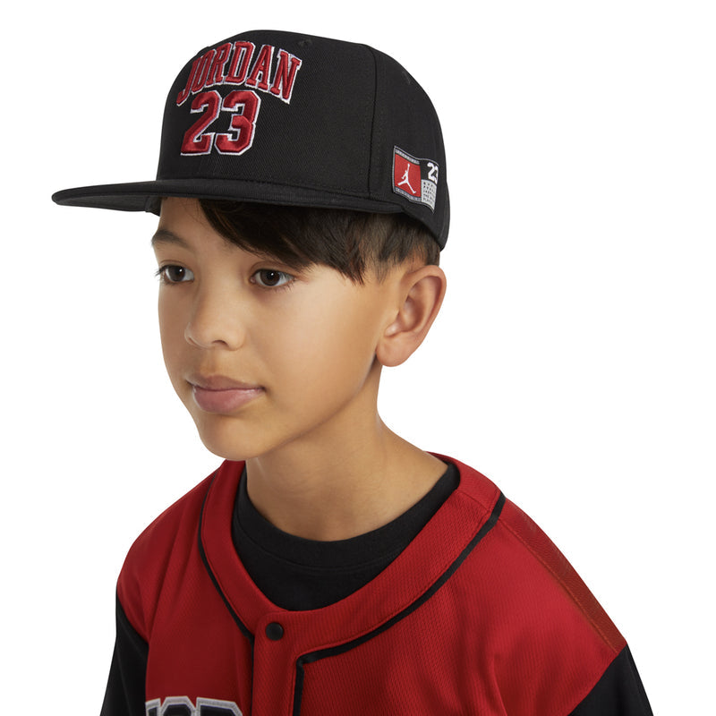 Black snapback worn by child, red 'JORDAN 23' front graphic and side patch