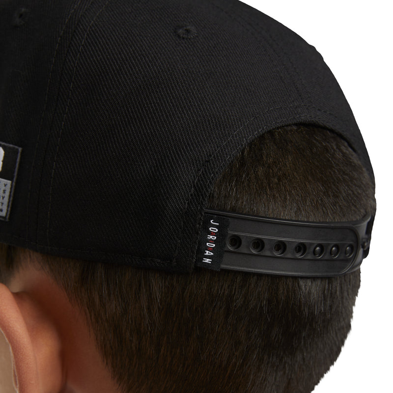 Black snapback underside with adjustable strap and small 'JORDAN' label