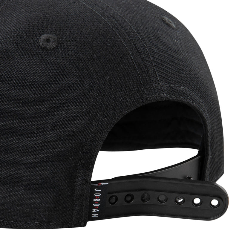Black snapback side view showing open back strap and 'JORDAN' label