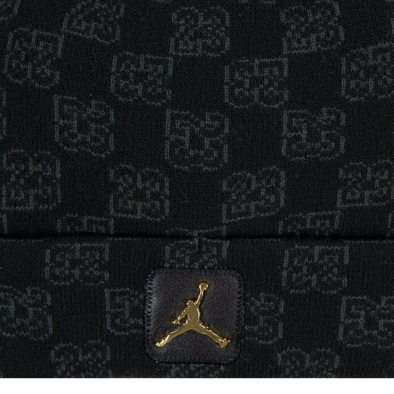 Close-up of dark knit beanie with gold Jordan logo patch